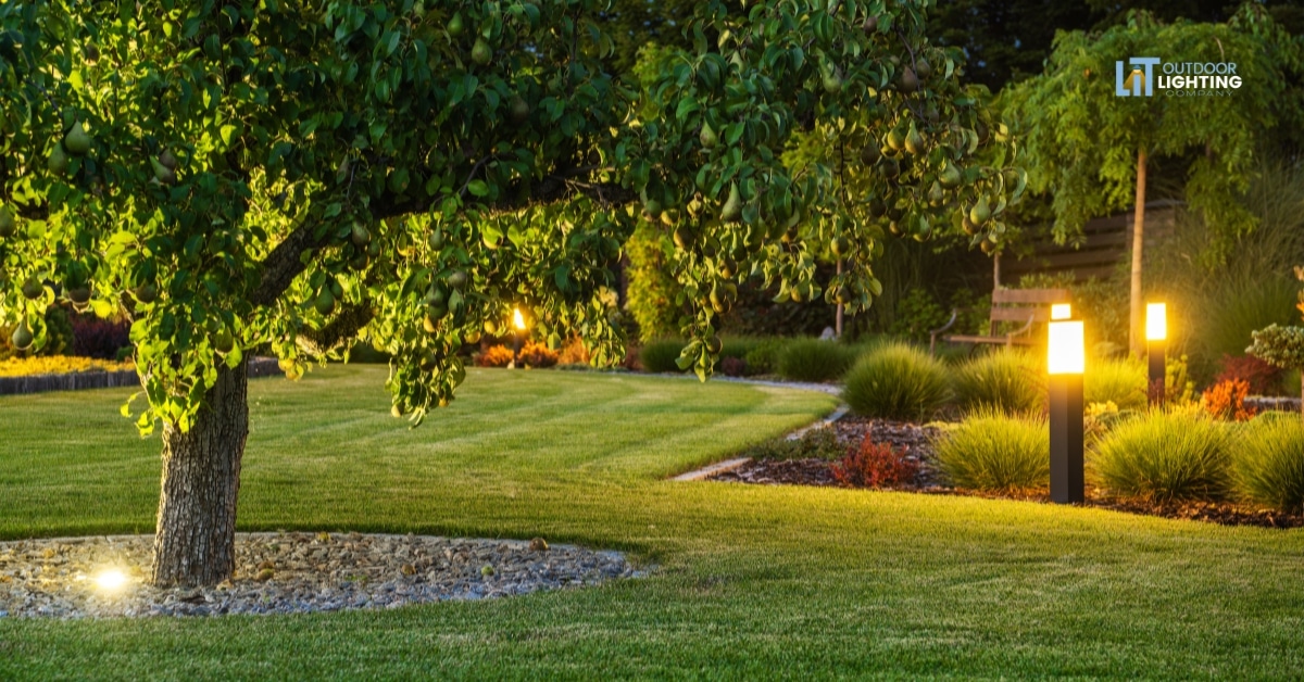 Front view of a modern luxury home glowing with warm landscape lighting at night