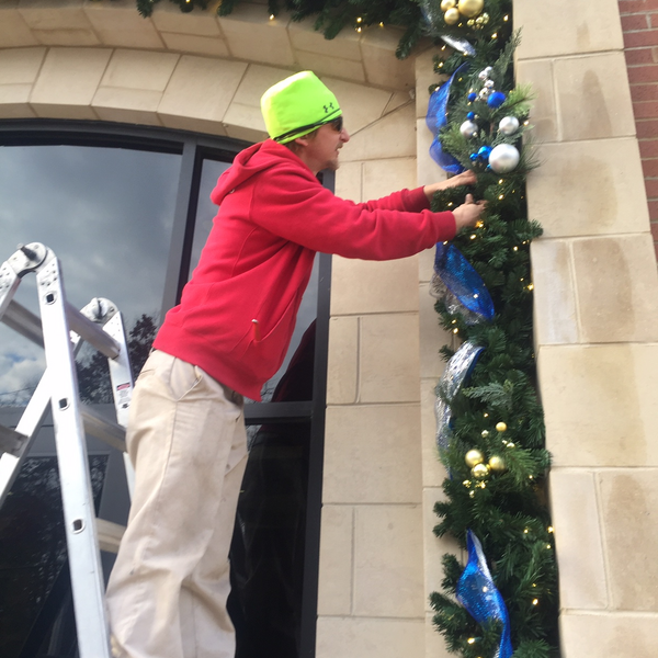 Electrician repairing outdoor outlet for Christmas lights.