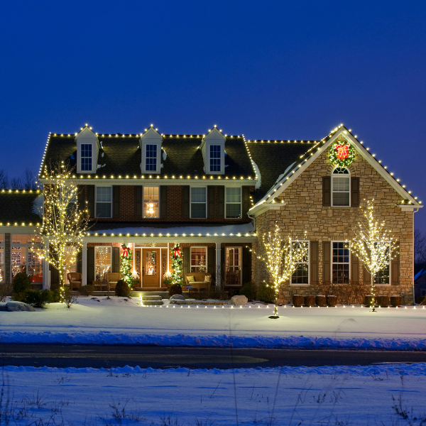 House decorated with outdoor Christmas lights at night.