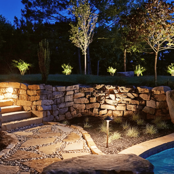 Technician setting up temporary lighting during a landscape lighting demo